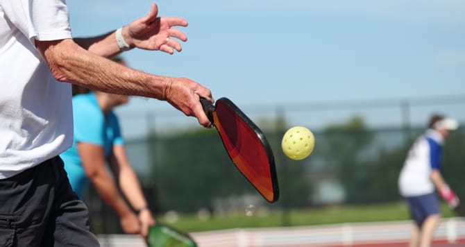 hiting pickleball with paddle